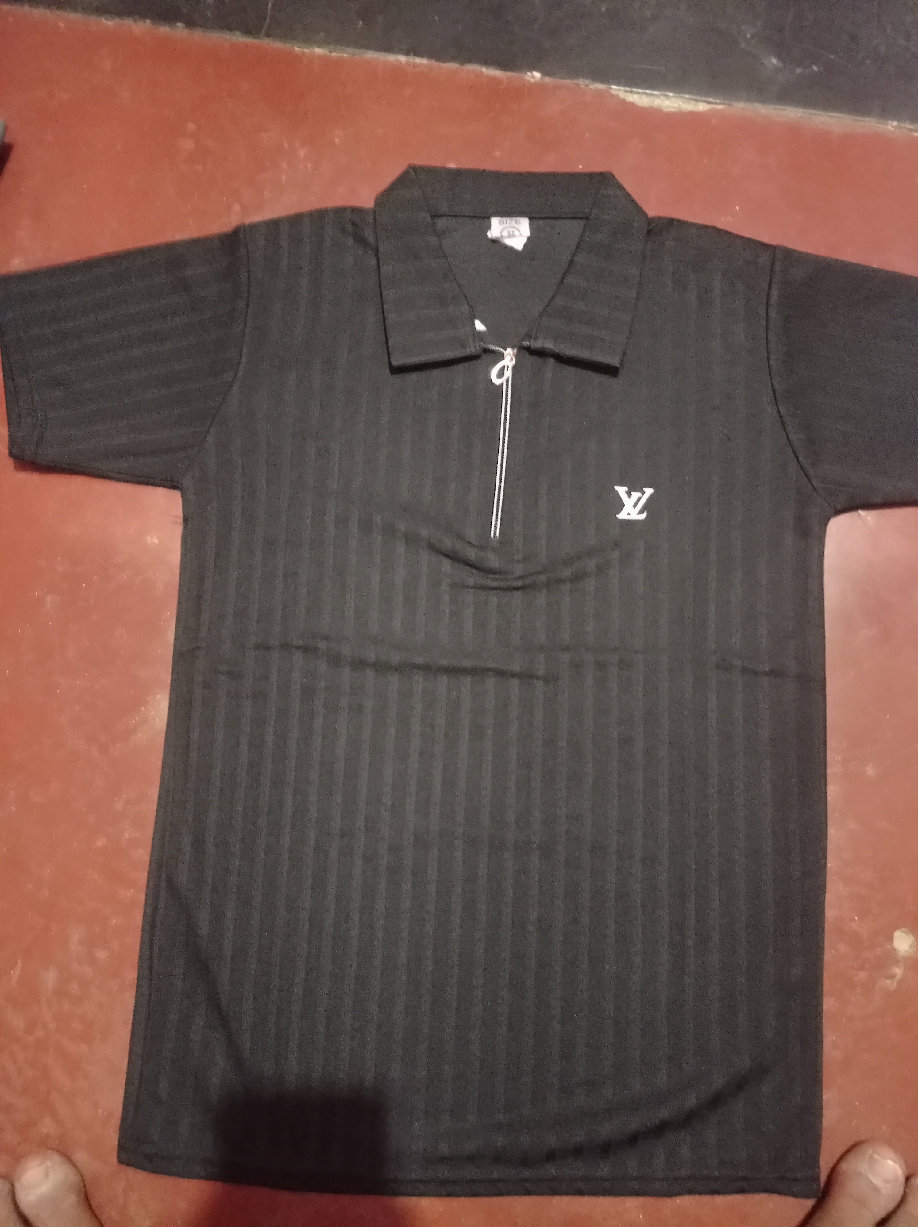 Black textured polo shirts with a quarter-zip colla
